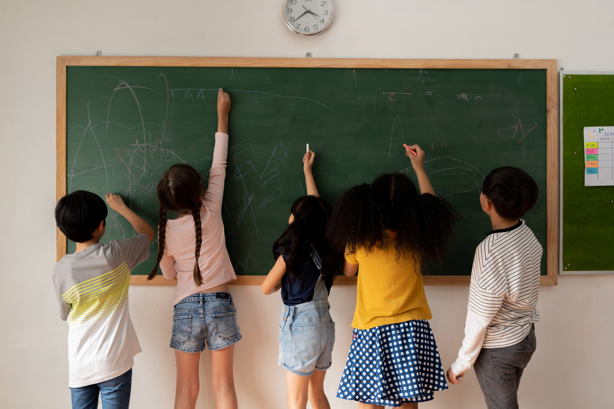 Elementary Students Writing on Blackboard